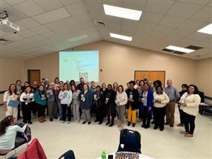 Large group of special educators standing in room for recognition
