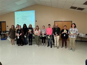 Exceptional Children's staff standing in room with their "Big Dill" awards.